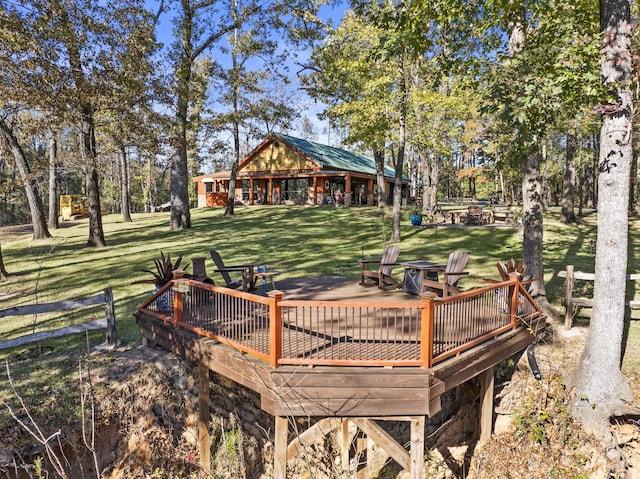 view of community featuring a lawn, a deck, and a fire pit