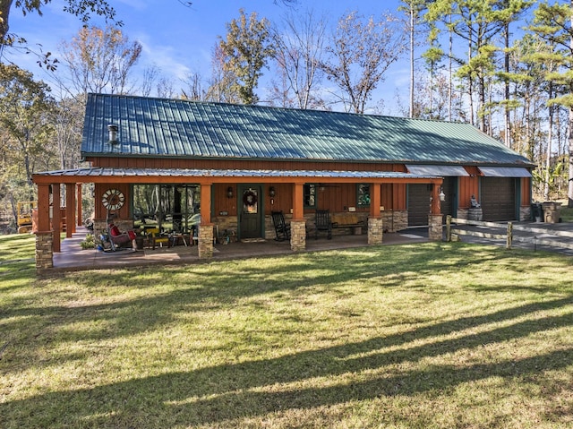 back of property featuring a garage and a yard