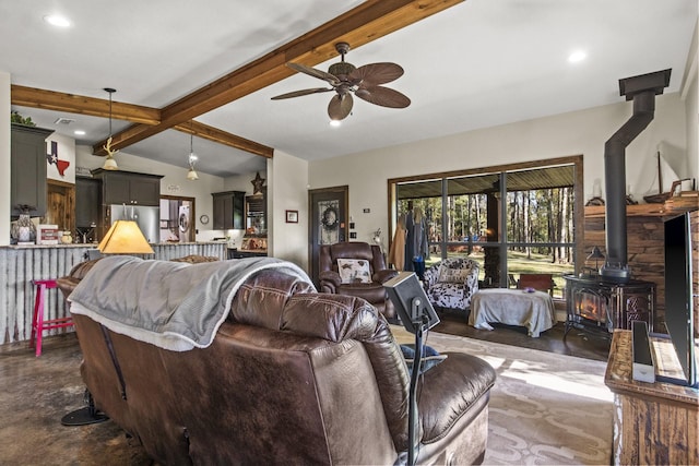 living room with ceiling fan, lofted ceiling with beams, and a wood stove