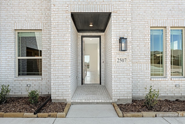 doorway to property with brick siding