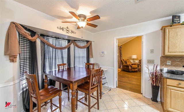 tiled dining area featuring ceiling fan, ornamental molding, and a textured ceiling