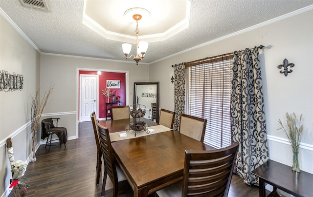 dining area with an inviting chandelier, ornamental molding, dark wood-type flooring, and a textured ceiling