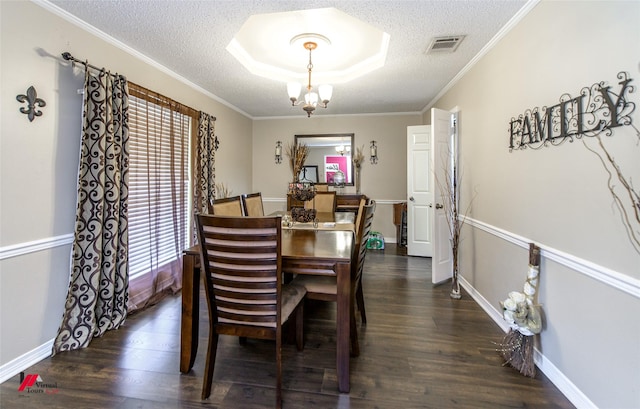 dining area with dark wood-type flooring, ornamental molding, an inviting chandelier, and a textured ceiling