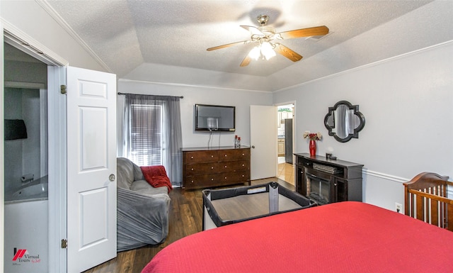 bedroom with lofted ceiling, a textured ceiling, dark hardwood / wood-style floors, ceiling fan, and a fireplace