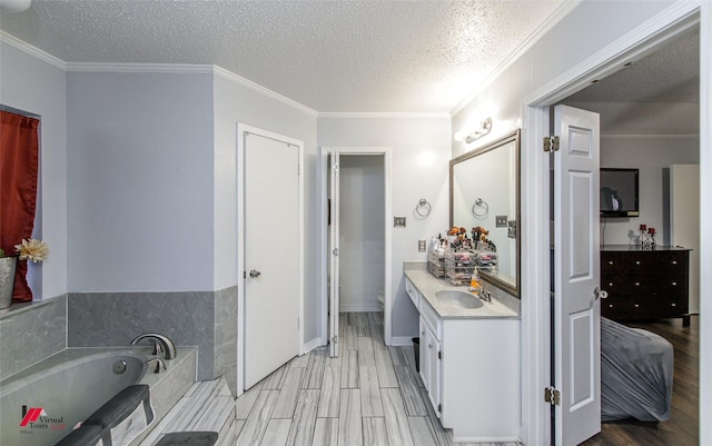 bathroom featuring wood-type flooring, a tub to relax in, vanity, crown molding, and a textured ceiling