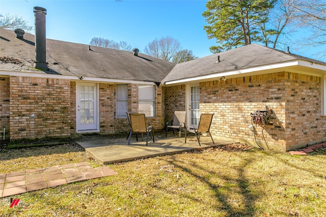 rear view of house with a lawn and a patio area