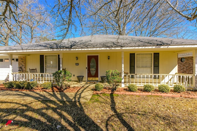 ranch-style house with a garage, a front yard, and covered porch