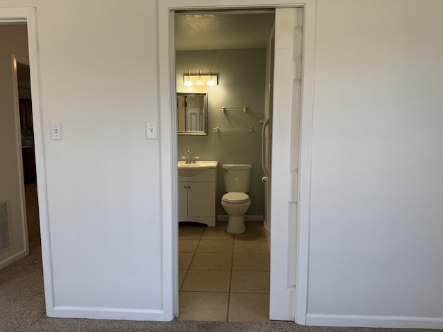 bathroom with tile patterned flooring, vanity, and toilet