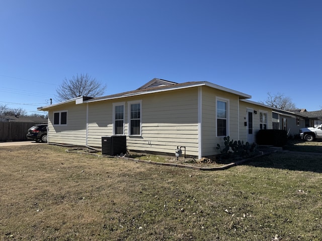 view of side of property with a yard and central air condition unit