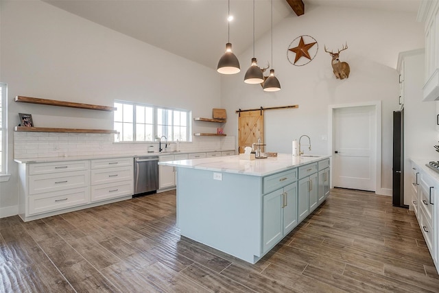 kitchen with white cabinetry, beam ceiling, stainless steel dishwasher, and a barn door