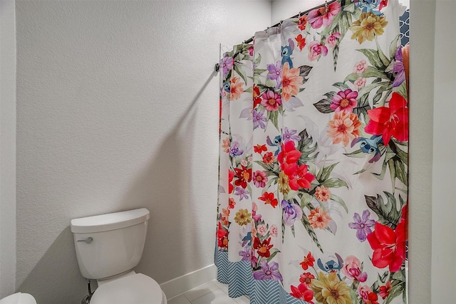 bathroom with toilet and tile patterned flooring