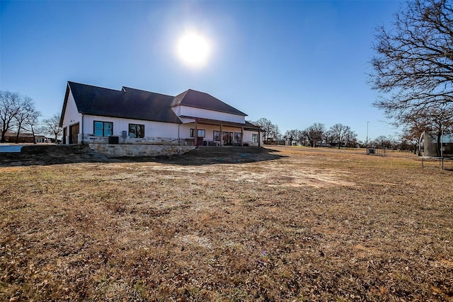 back of property with a trampoline and a lawn