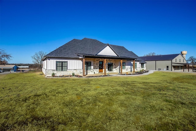 rear view of property featuring a yard and board and batten siding