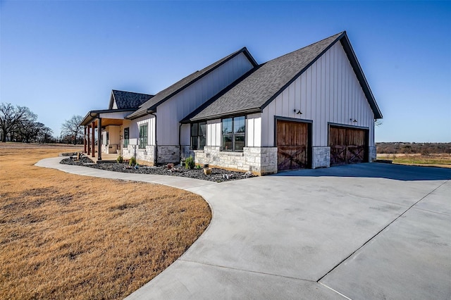 view of side of property with a garage and covered porch