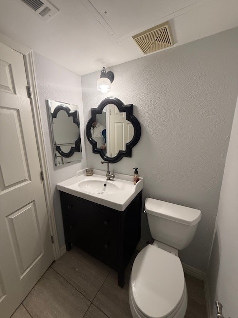 bathroom featuring vanity, toilet, and tile patterned flooring