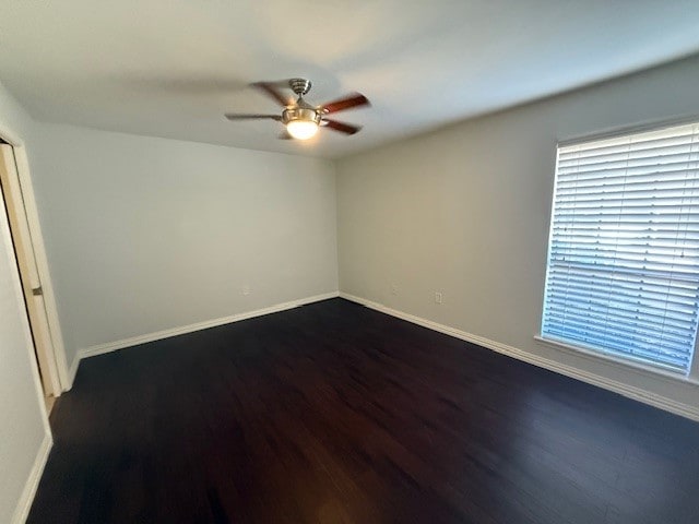 spare room with dark hardwood / wood-style floors and ceiling fan