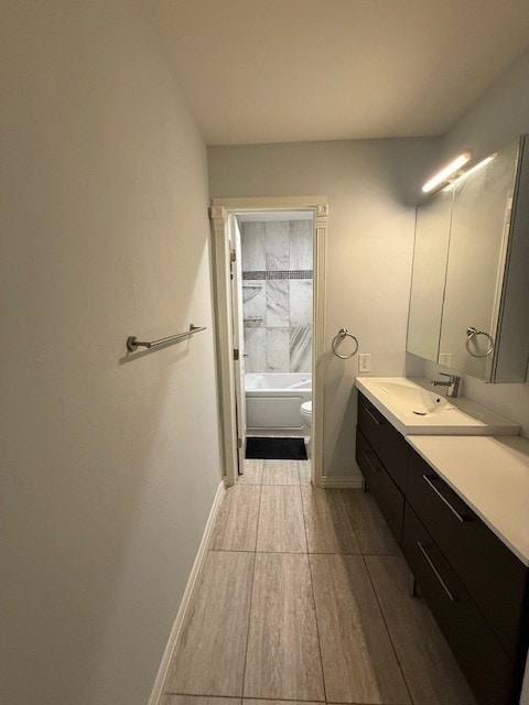 full bathroom with shower / tub combination, hardwood / wood-style floors, vanity, and toilet