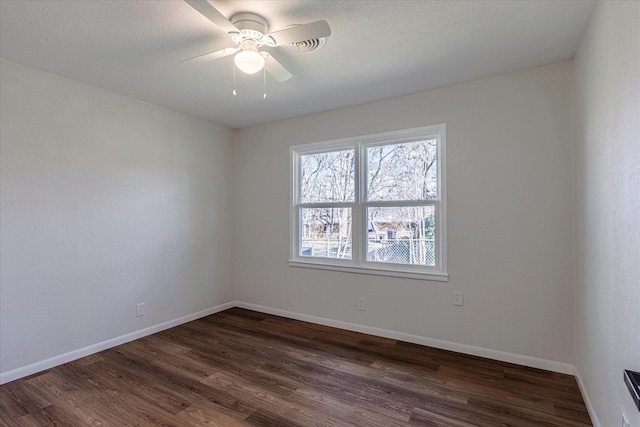 empty room featuring dark hardwood / wood-style flooring and ceiling fan