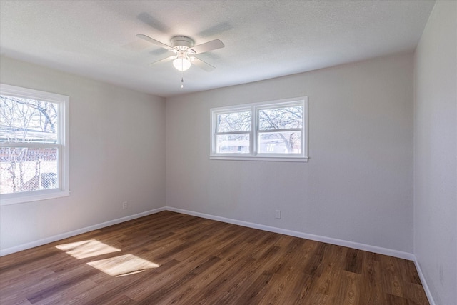 empty room featuring ceiling fan, a textured ceiling, and dark hardwood / wood-style flooring