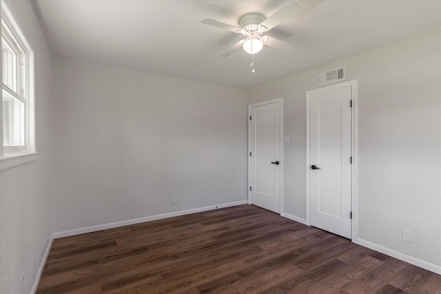 unfurnished bedroom with ceiling fan and dark hardwood / wood-style flooring