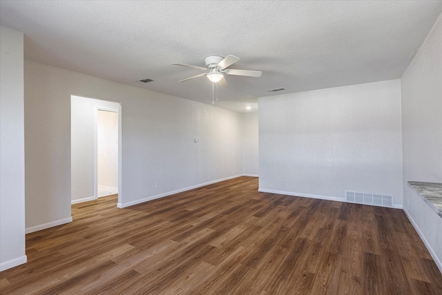 empty room with dark wood-type flooring, ceiling fan, and a textured ceiling