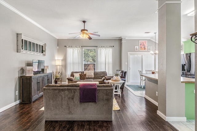 living room with ceiling fan with notable chandelier, ornamental molding, dark hardwood / wood-style flooring, and decorative columns