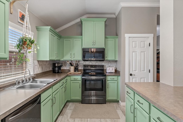 kitchen featuring sink, green cabinetry, vaulted ceiling, stainless steel appliances, and decorative backsplash