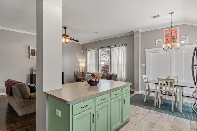 kitchen featuring green cabinetry, decorative light fixtures, vaulted ceiling, ornamental molding, and ceiling fan with notable chandelier