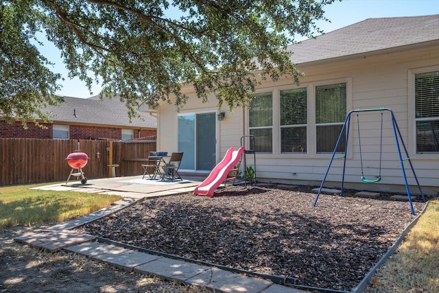 back of property with a playground and a patio