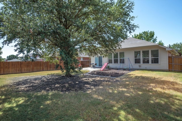 rear view of property featuring a lawn and a patio area