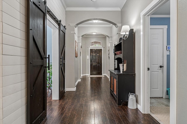 hallway featuring dark hardwood / wood-style floors, a barn door, and crown molding