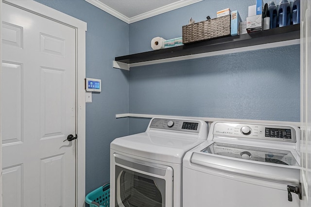 washroom featuring ornamental molding and washing machine and dryer