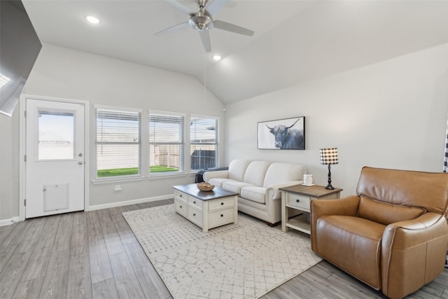 living room featuring lofted ceiling, ceiling fan, and light hardwood / wood-style flooring