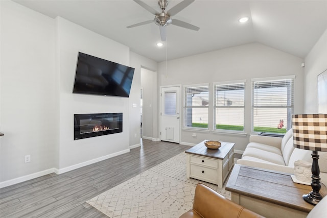 living room featuring ceiling fan, lofted ceiling, and light wood-type flooring