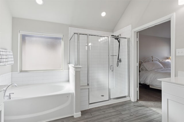 bathroom with lofted ceiling, wood-type flooring, and shower with separate bathtub