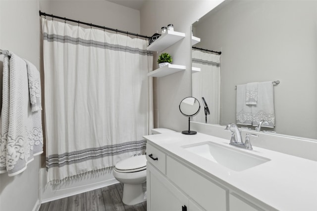 full bathroom with shower / bathtub combination with curtain, hardwood / wood-style floors, vanity, and toilet