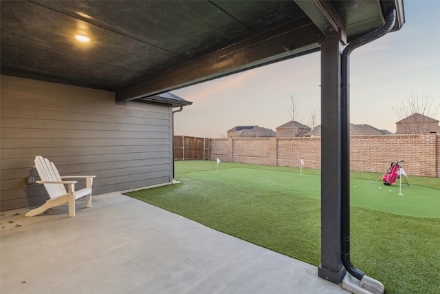 yard at dusk featuring a patio area