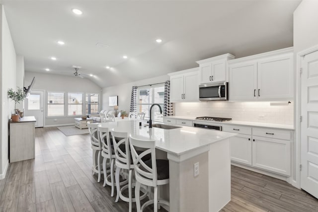 kitchen with white cabinetry, sink, vaulted ceiling, and stainless steel appliances