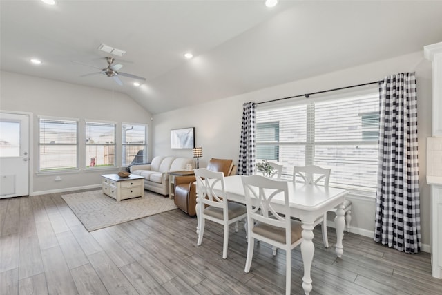 dining room featuring lofted ceiling, a wealth of natural light, and light hardwood / wood-style floors