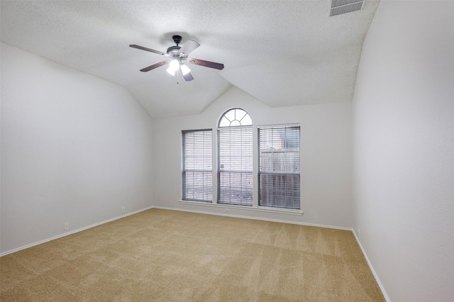 carpeted spare room with ceiling fan, lofted ceiling, and a textured ceiling