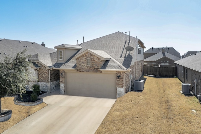 view of front of home with a garage and central AC