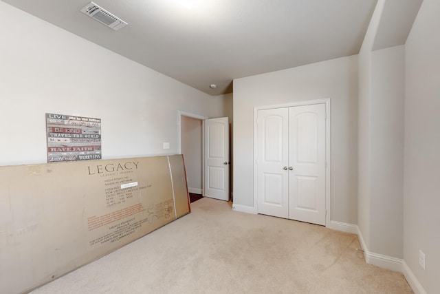 bedroom featuring light colored carpet and a closet