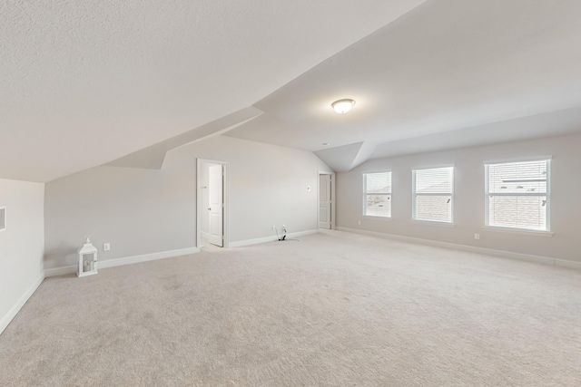 bonus room featuring lofted ceiling and light colored carpet