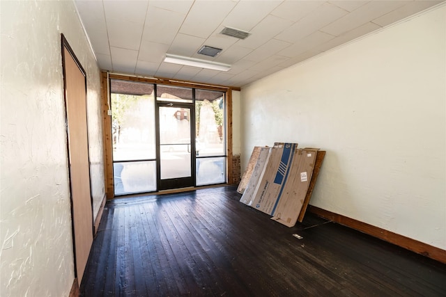 spare room featuring floor to ceiling windows and dark hardwood / wood-style floors