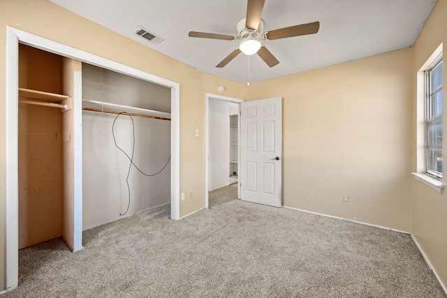 unfurnished bedroom featuring ceiling fan, a closet, and light carpet