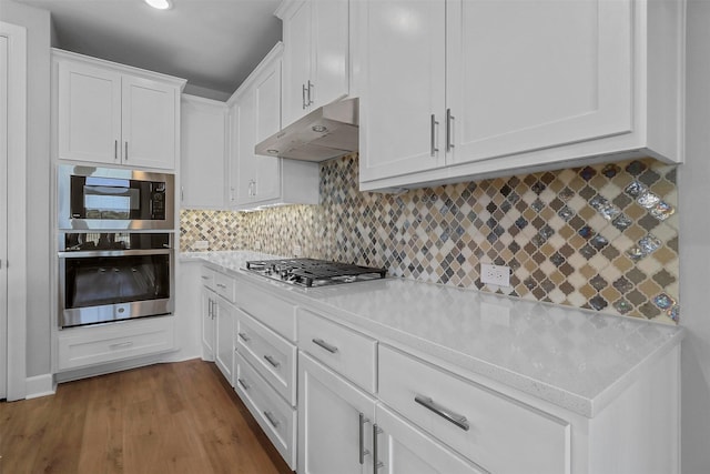 kitchen with white cabinetry, light stone counters, tasteful backsplash, stainless steel gas cooktop, and light wood-type flooring