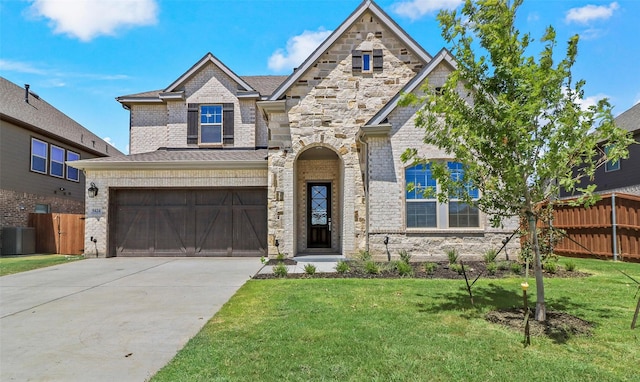 view of front of house featuring cooling unit, a garage, and a front yard