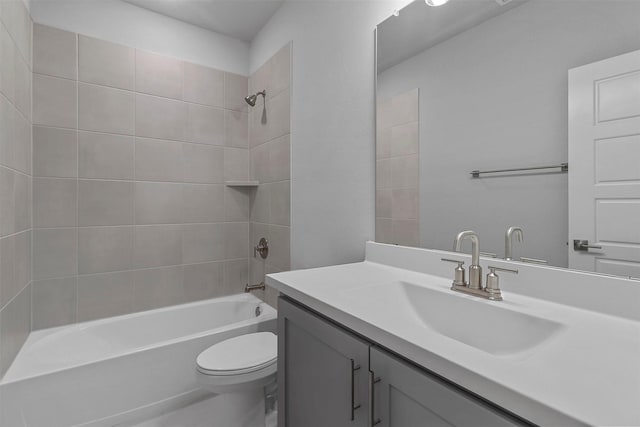 full bathroom featuring vanity, tiled shower / bath combo, and toilet