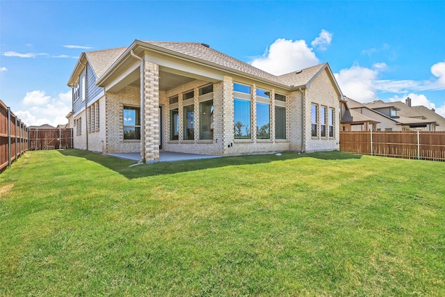 back of house featuring a lawn and a patio