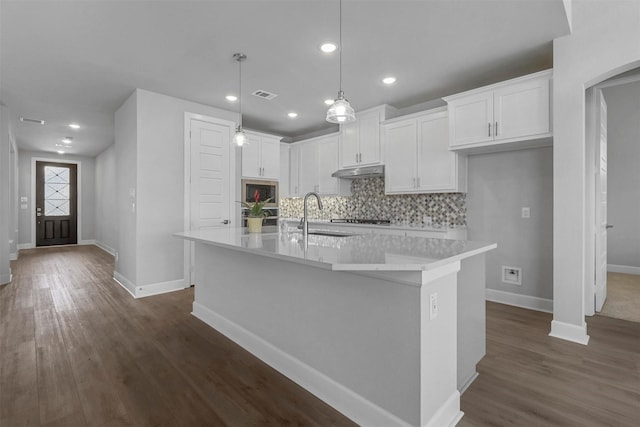 kitchen with pendant lighting, sink, dark wood-type flooring, a kitchen island with sink, and white cabinetry